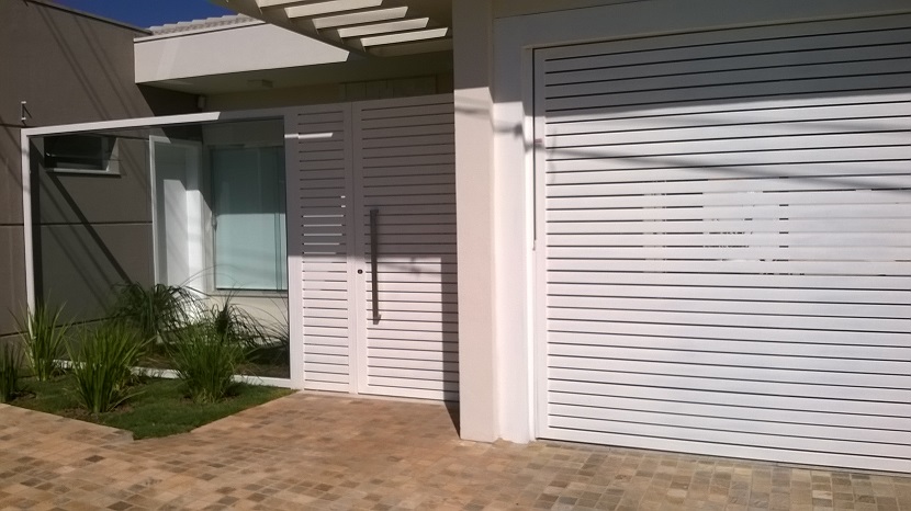 Fachada contemporânea com portão e porta social em alumínio composto